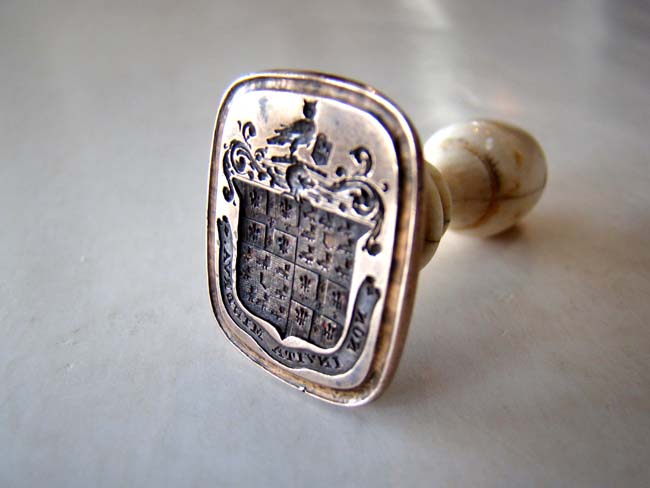 An 18th century ivory mounted brass desk seal with elaborate coat-of-arms and the latin phrase 'Non Invita Minerva.'